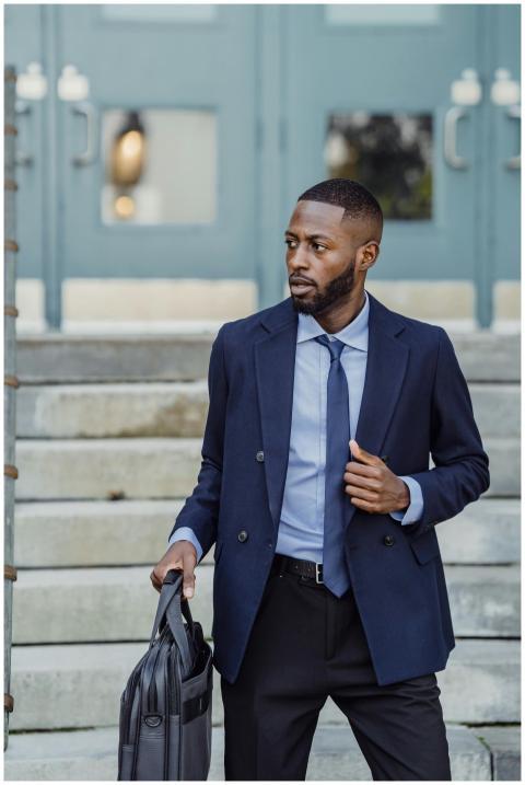 A well-dressed businessman holding a laptop bag on