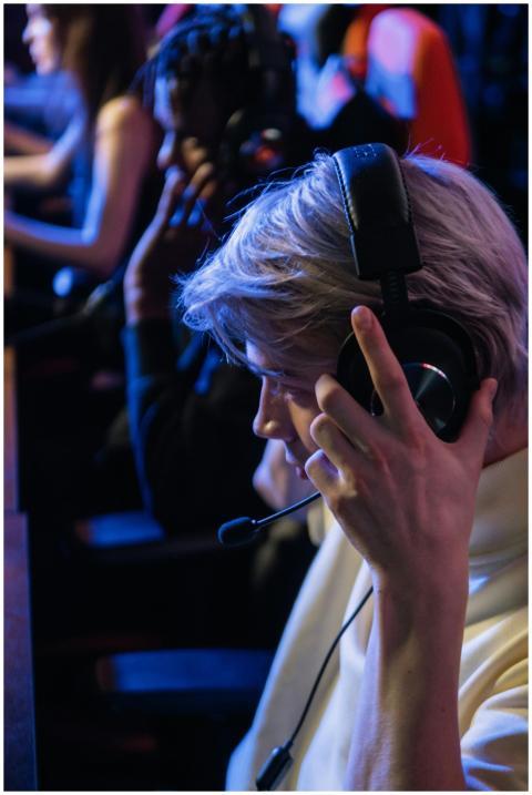 A young adult immersed in a gaming tournament, wea