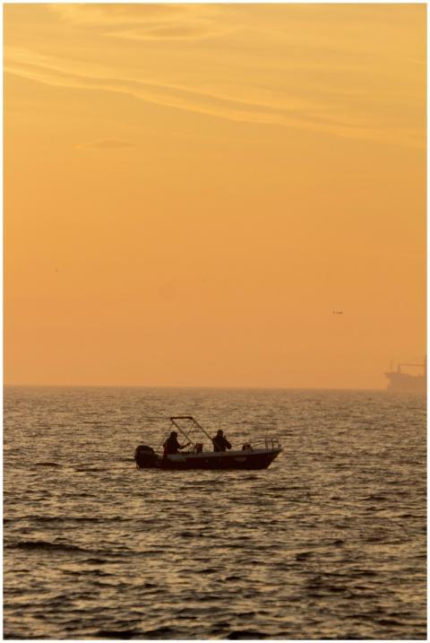 A serene scene of a small boat at sunrise in the w
