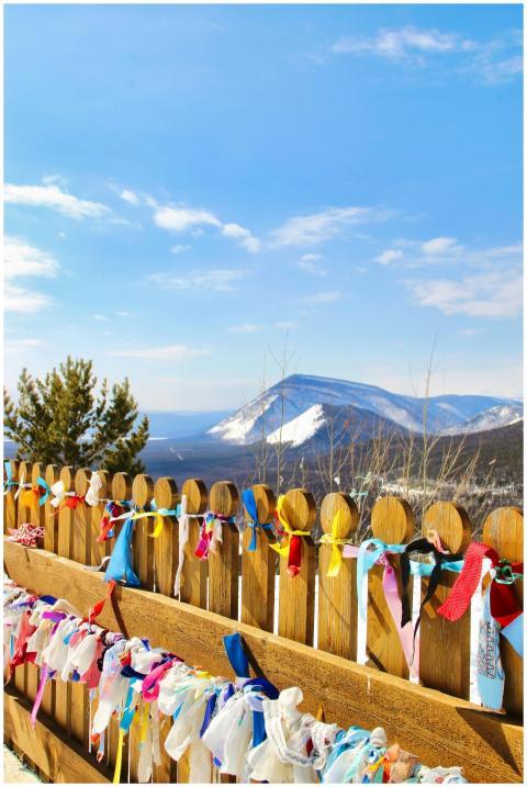 Colorful ribbons tied on a wooden fence with snowy