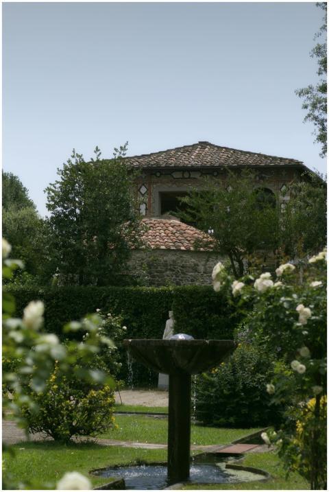 A picturesque garden in Tuscany with a stone fount