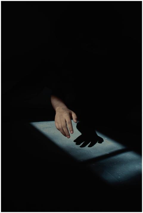 Silhouette of a hand in dramatic low-light casting