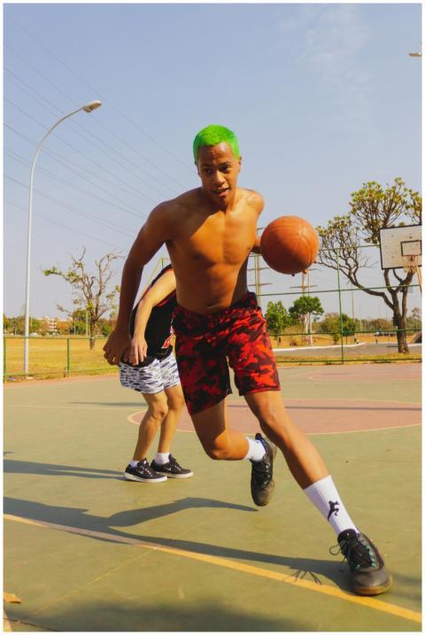 Male athlete with green hair playing basketball ou