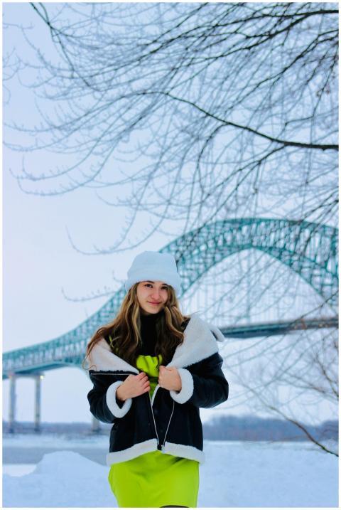 A fashionable woman in winter attire stands near a