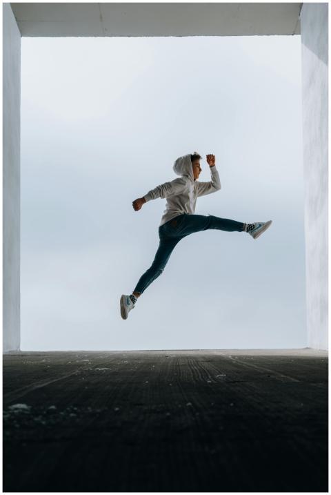 A boy in a hoodie performing a high vertical jump