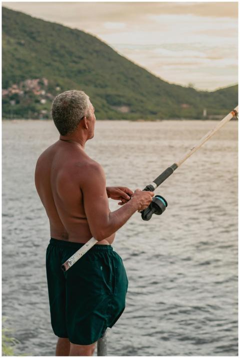 A man enjoys fishing by a serene lake, casting his