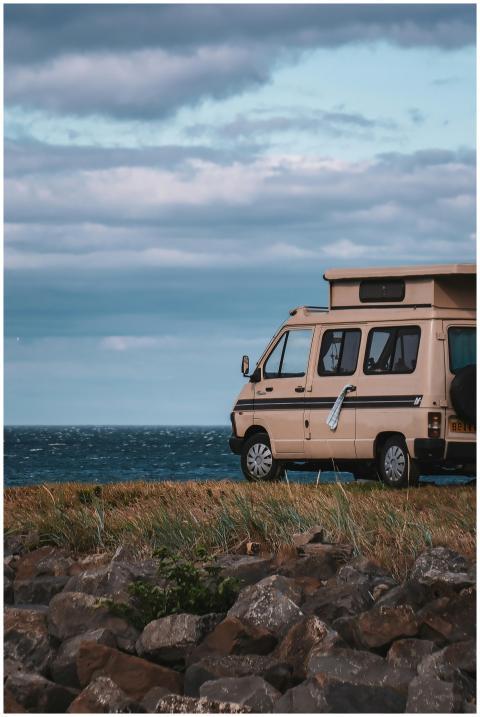 A charming campervan parked by the tranquil sea al