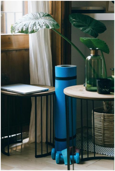 A cozy home office corner with yoga mat, weights,
