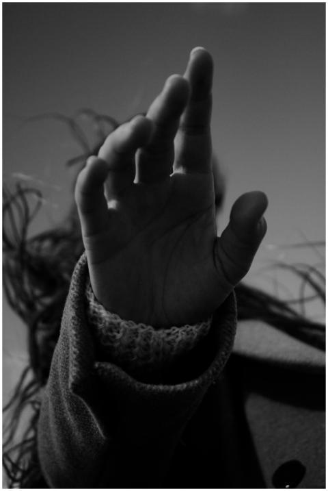 Artistic monochrome image of a raised hand in a kn