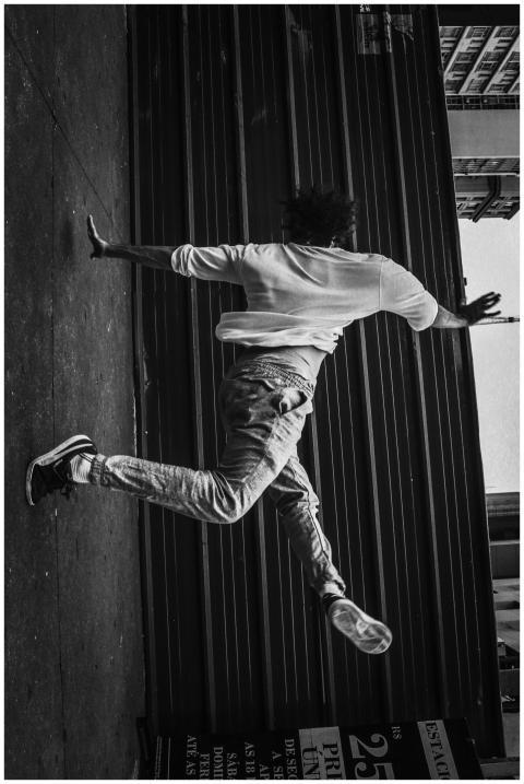 Energetic street dancer captured mid-jump in a sty
