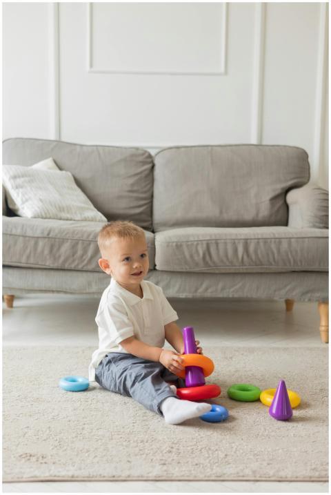 Cute infant plays with vibrant toy rings on the li