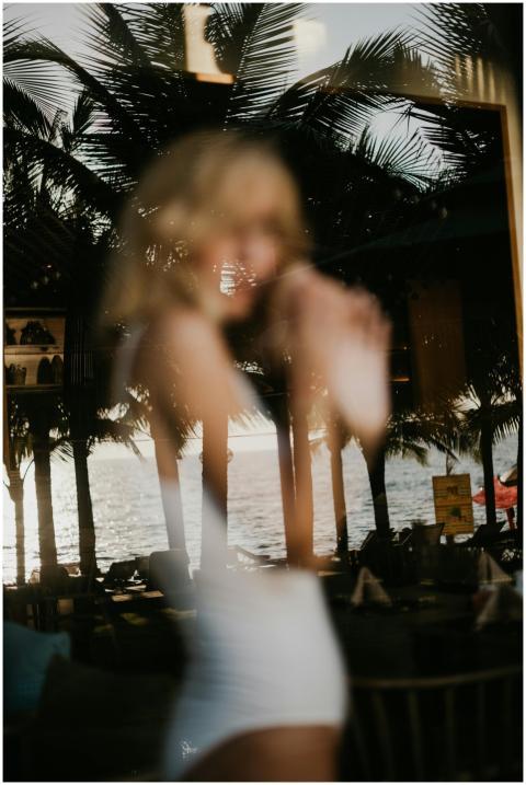 A dreamy reflection of a woman in Bali with palm t