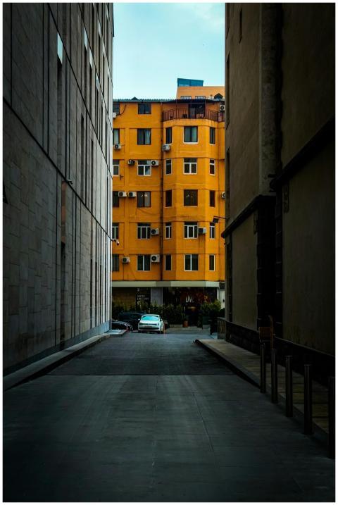 A vibrant yellow apartment building seen through a