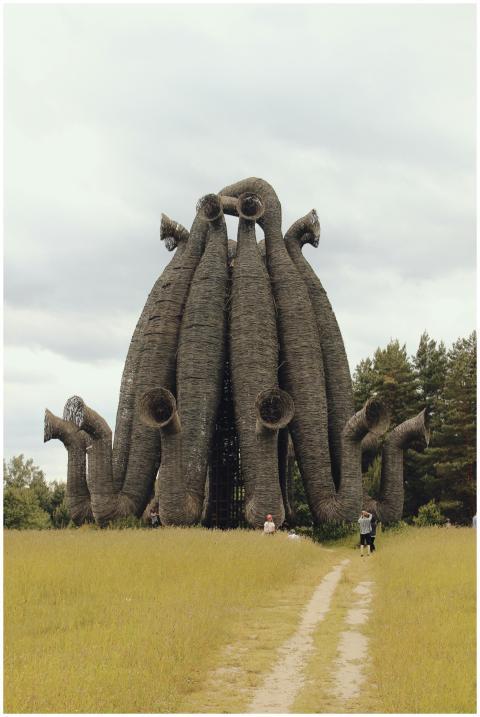 A striking wicker structure stands amidst a grass