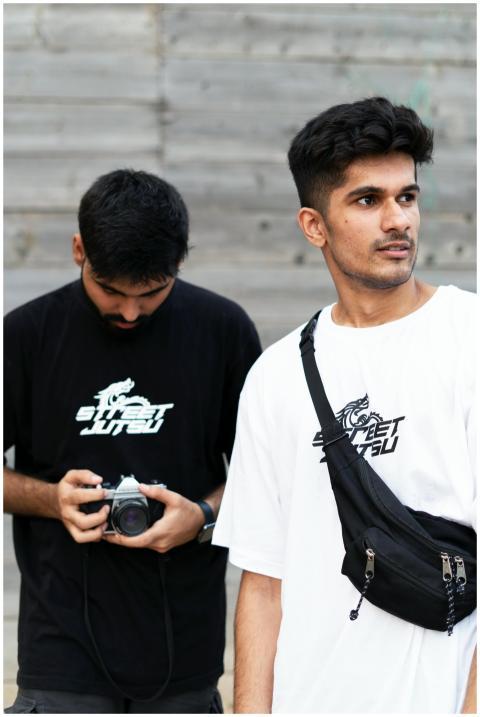 Two young men with casual outfits explore urban su