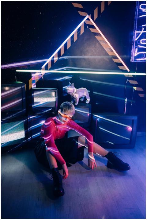 A person in vibrant neon lighting with a geometric