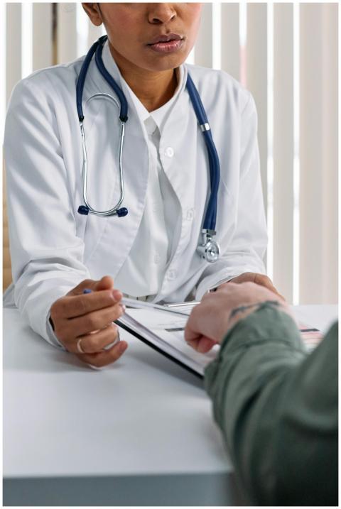 A doctor in a white coat consulting a patient at a