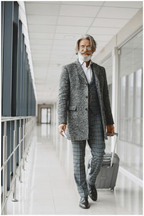 Senior man with gray hair and beard walking throug