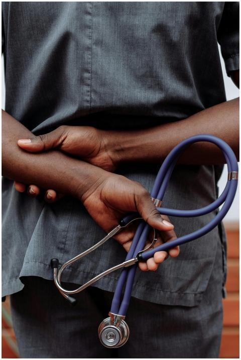Medical professional in gray scrubs holding stetho