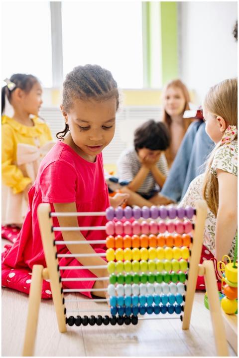 Happy children exploring an abacus in a lively cla
