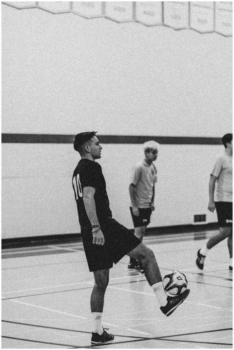 Black and white image of men playing indoor soccer