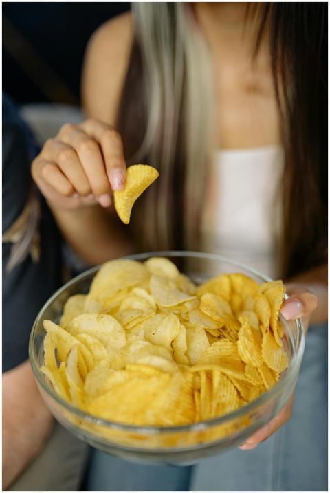Young woman enjoying a bowl of crispy potato chips