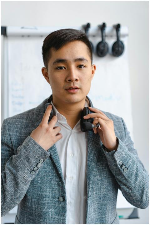 Young businessman in modern office attire adjustin