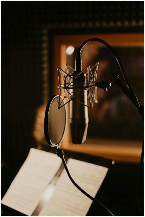 Close-up of a microphone and pop filter in a dimly