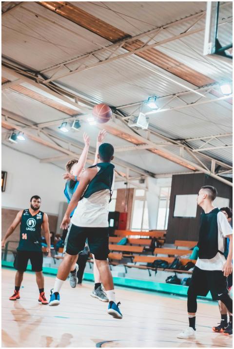 Young athletes playing basketball indoors showcasi