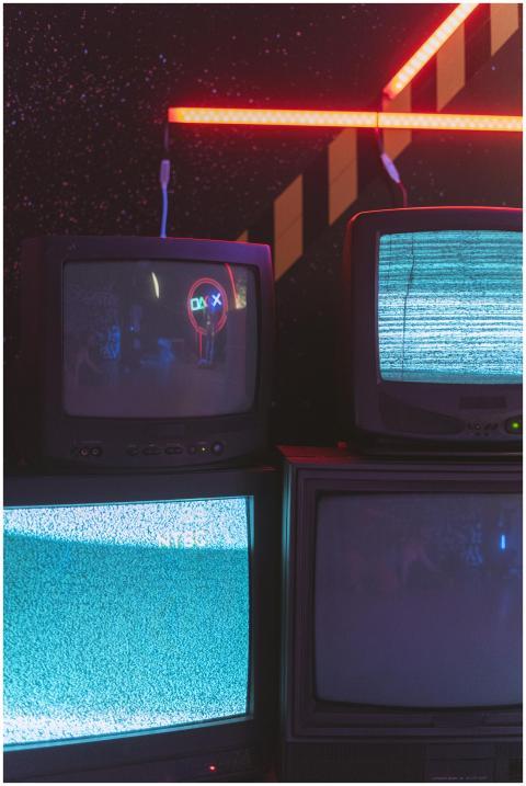 A collection of old CRT televisions displaying sta