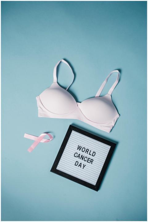 Flat lay with bra, pink ribbon, and message board