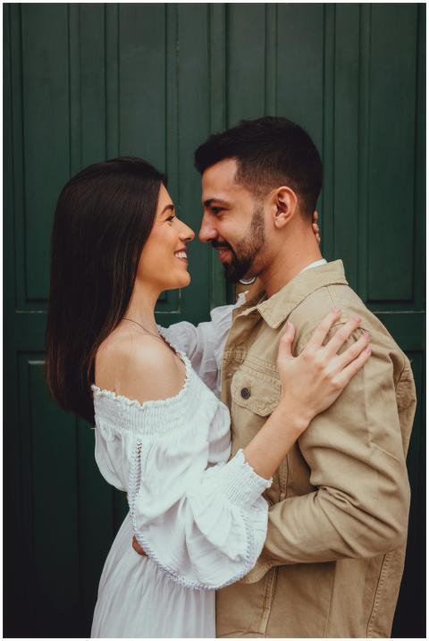 A romantic couple embraces and smiles at each othe