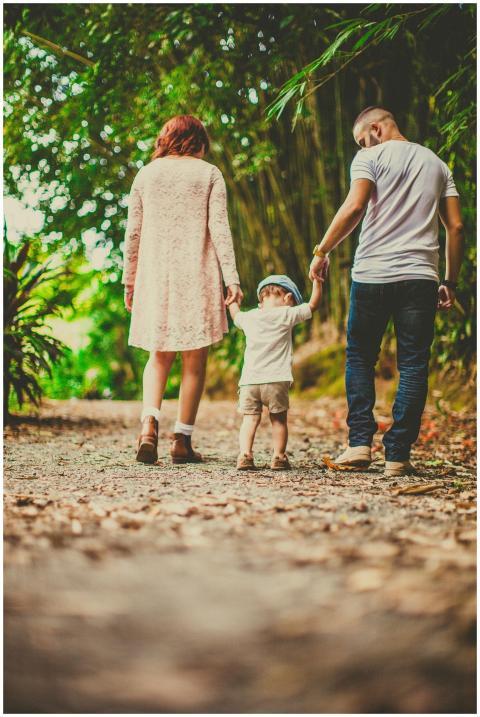 A family enjoys a leisurely walk in a green park,