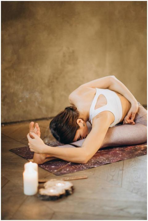 A woman performing seated forward bend yoga pose o
