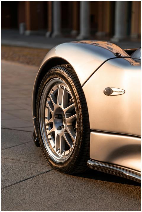 Detailed view of a luxury silver sports car wheel