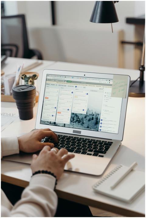 Hands typing on a laptop in a modern office settin