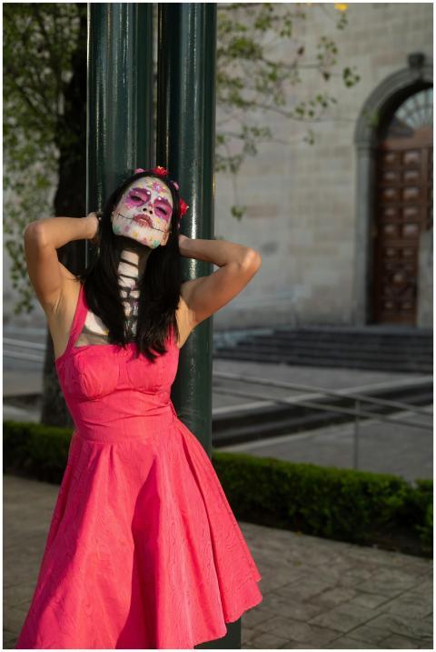 Woman with festive Day of the Dead makeup poses in