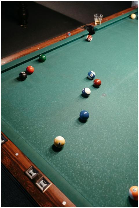 Billiard balls arranged on a green pool table in a