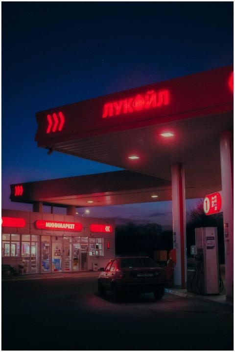 A dimly lit gas station with neon signs glowing in