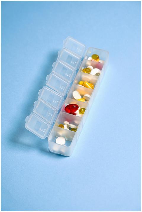 Colorful pills and capsules organized in a weekly
