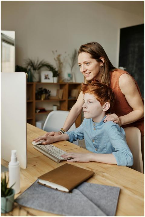 A mother helps her son with online learning on a h