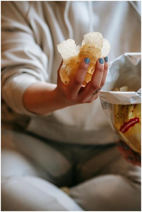 A close-up image of a female hand holding crispy p