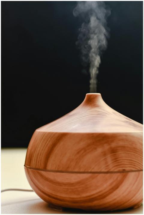 A wooden diffuser releasing calming steam against