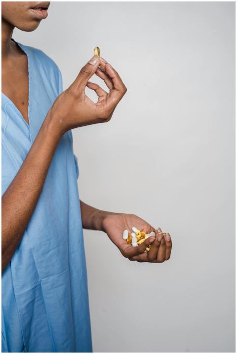 Close-up of a woman holding a variety of capsules