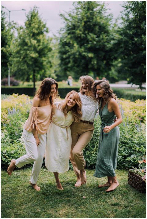 Group of four happy women laughing and embracing o