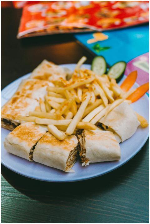 Appetizing Mediterranean wrap with fries served on