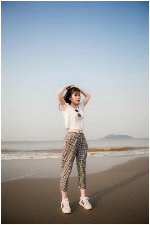 Young woman in crop top and plaid pants posing on