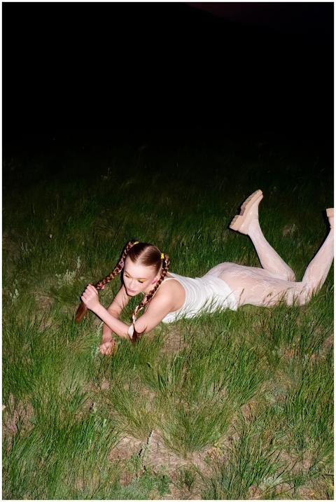 Young woman with braids posing on a grassy field u
