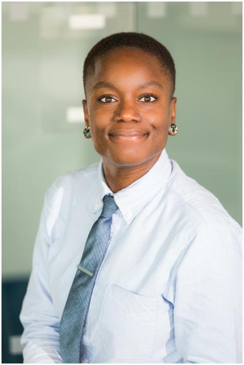 Smiling woman in office setting, wearing formal at