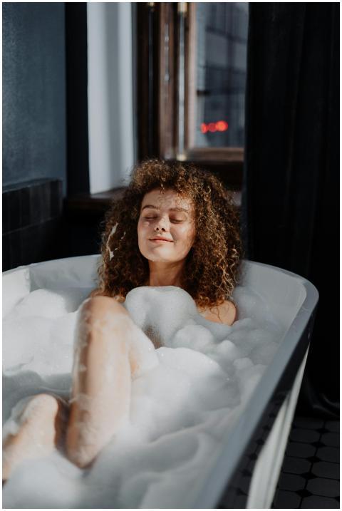A young woman with curly hair enjoys a relaxing bu